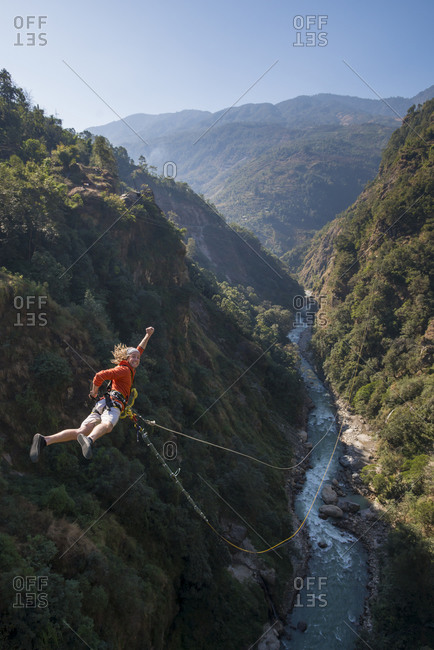 A flying jump with a smile at the one of the world's biggest canyon swings at The Last Resort in Nepal