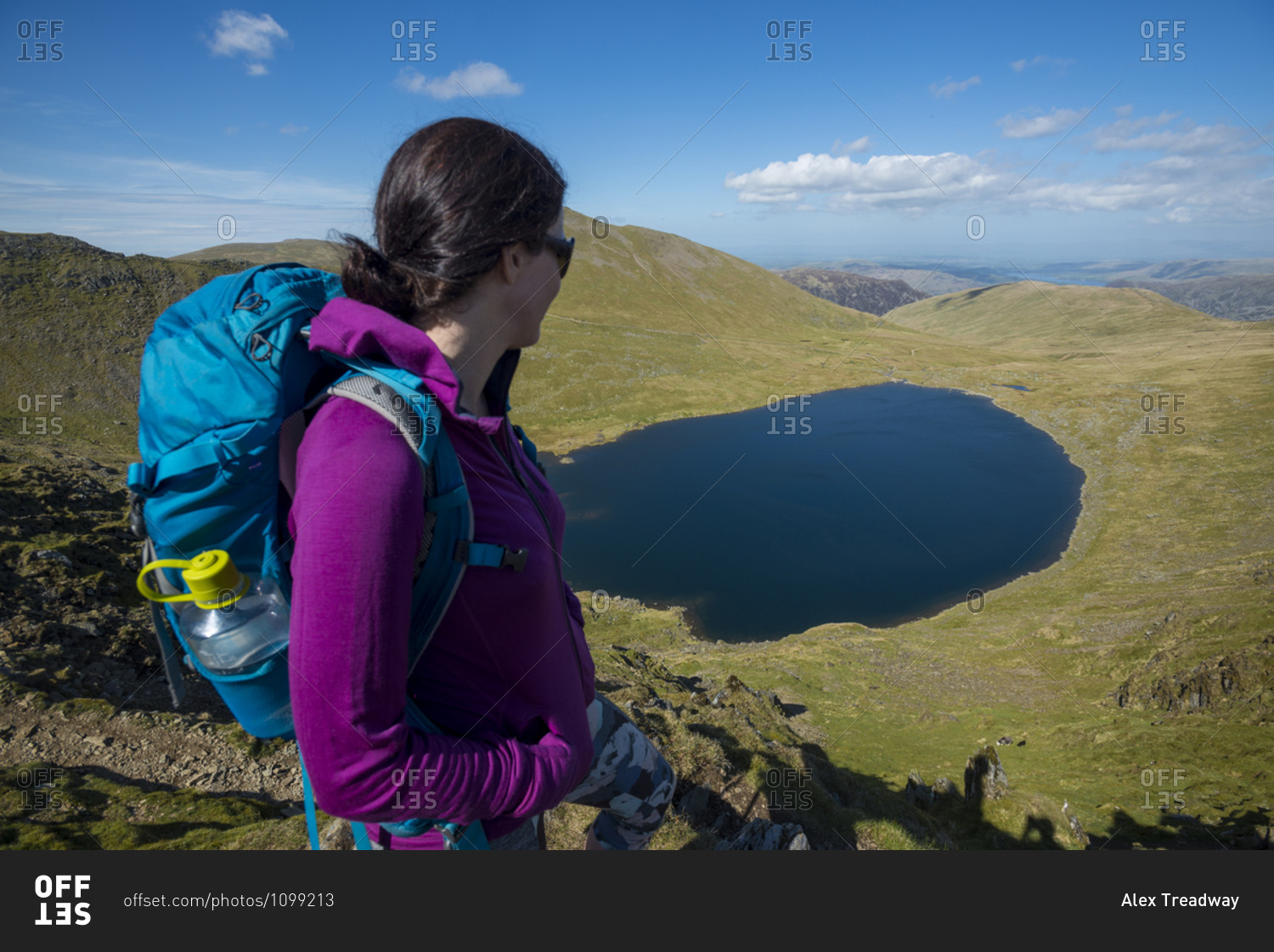 A woman stands on top of Striding Edge facing towards Red Tarn in the English Lake District