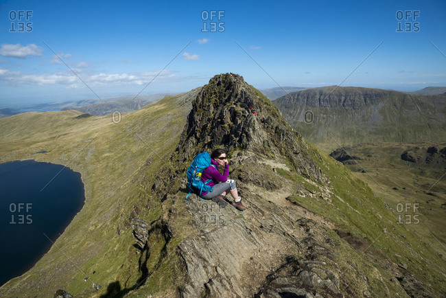 A woman sits on top of Striding Edge in the English Lake District