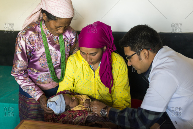 Diktel Hospital, Nepal - December 9, 2015: A mother has her baby checked by a doctor at a rural hospital in Nepal, Khotang District
