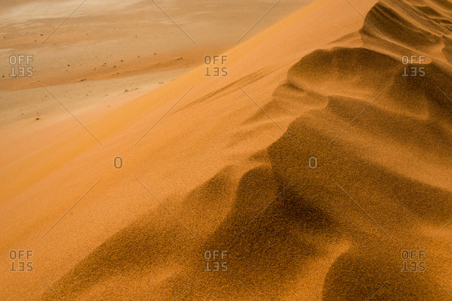 Strong wind on top of Sossusvlei sand dune in the Namib desert clears away foot prints and shapes the sand.