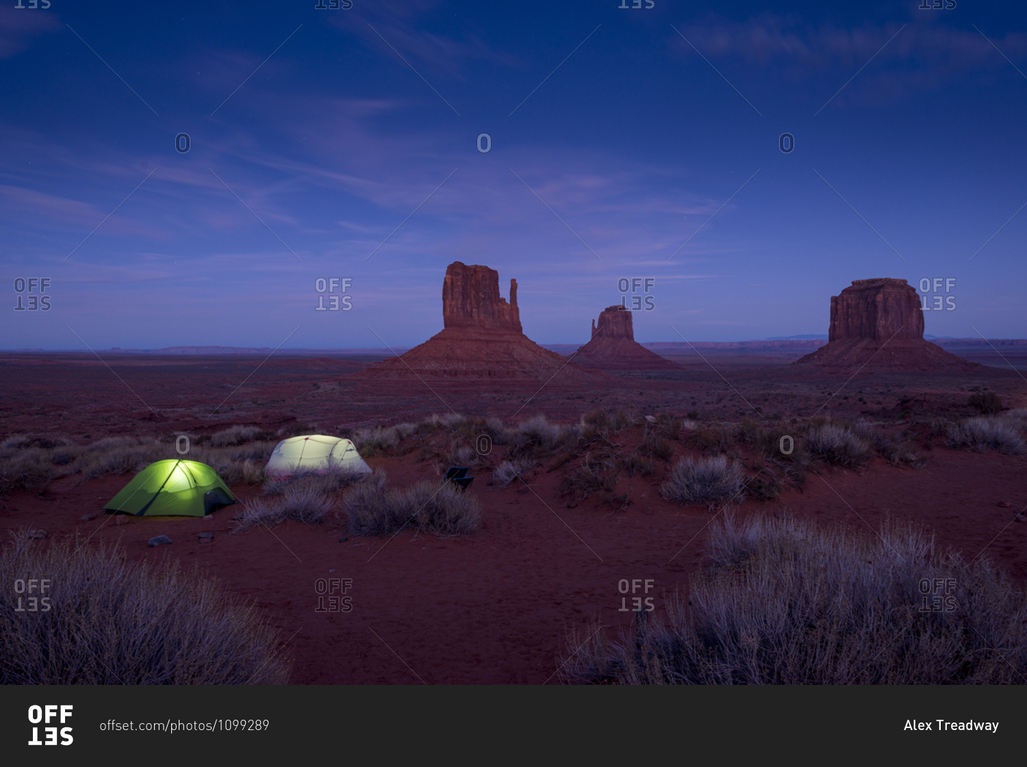 Tents glowing after dark while camping in the Monument valley Navajo tribal park on the with views of the giant sandstone buttes in the distance