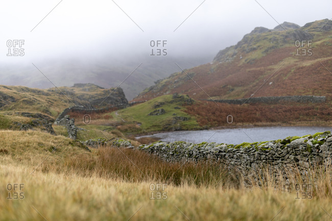 Alcock Tarn by a dry stone wall in the The Lake District