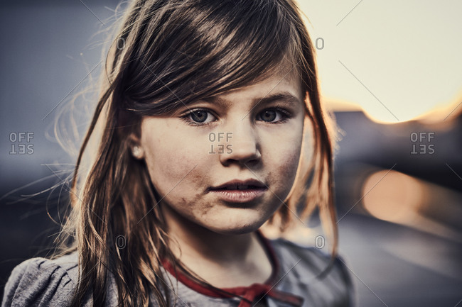 A pretty young girl with a dirty face looing at the camera