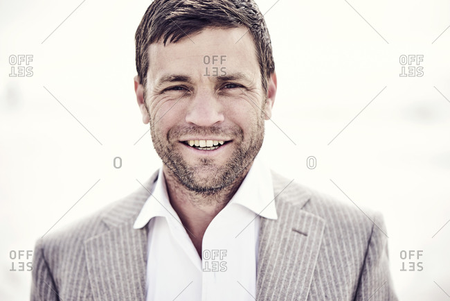 Portrait of a smiling man in a suit outside on sunny day