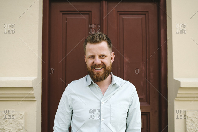 Smiling man standing against door