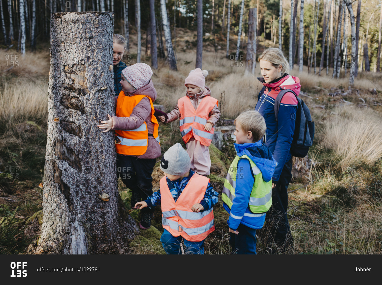 Playschool teachers with children in forest