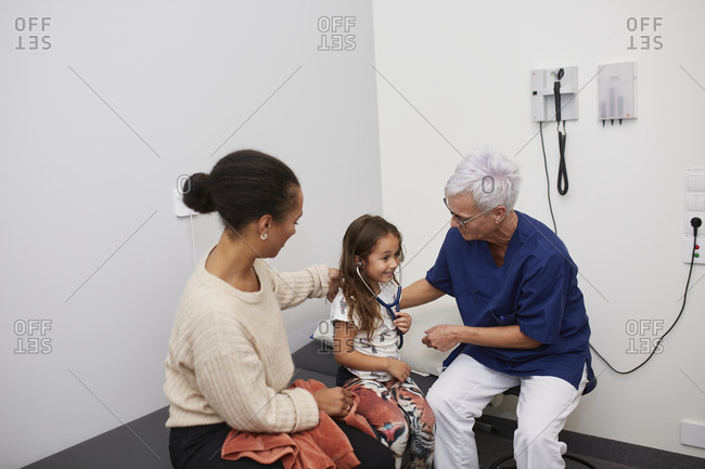 Doctor examining girl in health center