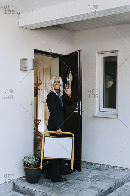 Female estate agent standing in open entrance door
