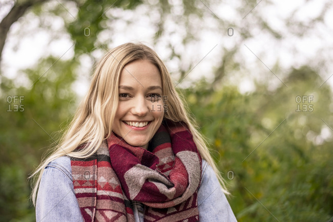 Blond woman with scarf in park during autumn
