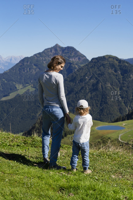Mother hiking with little daughter in springtime mountains