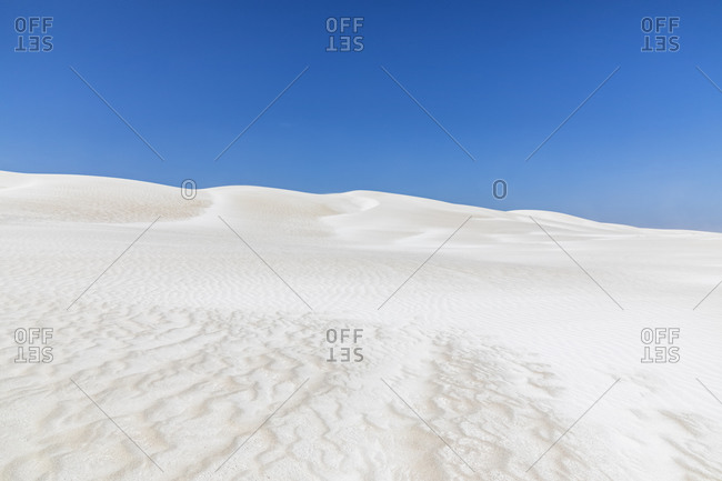 Clear blue sky over white sand dunes