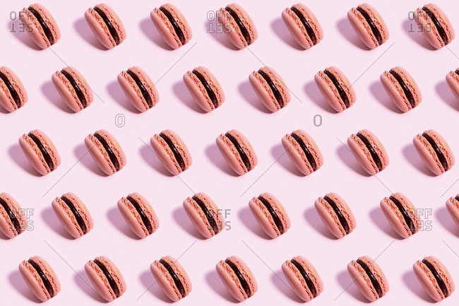 Pattern of pink macaroon cookies against pink background