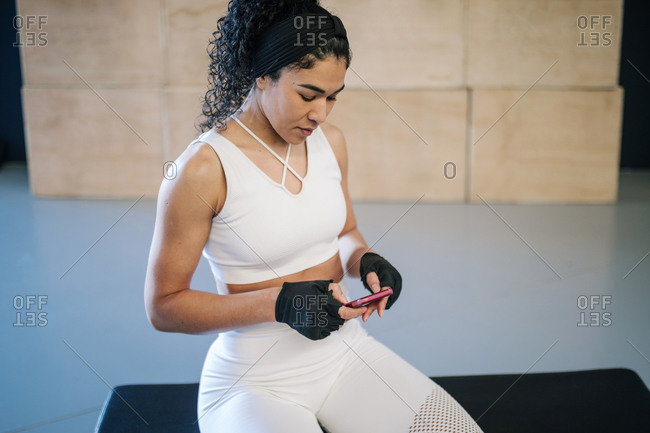 Sportswoman using mobile phone in gym