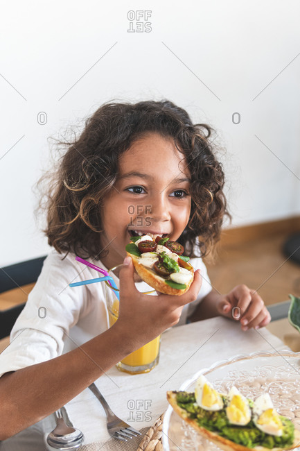 Portrait of little girl eating breakfast