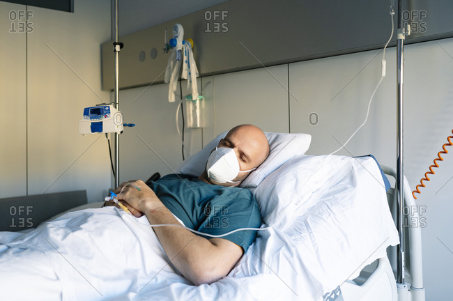 Male patient sleeping on bed in hospital