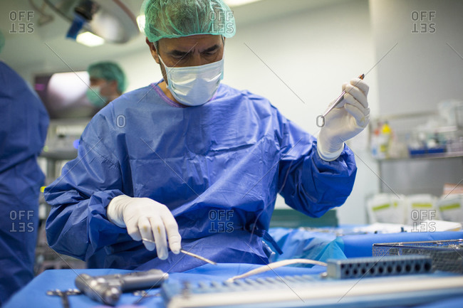 Mature male surgeon preparing medical equipment in ICU at hospital