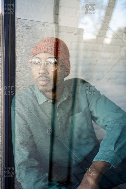 Mid adult man contemplating while looking through window