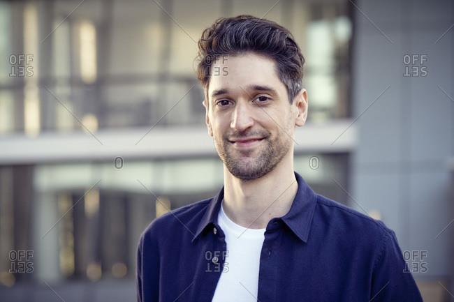 Smiling entrepreneur standing outdoors alone