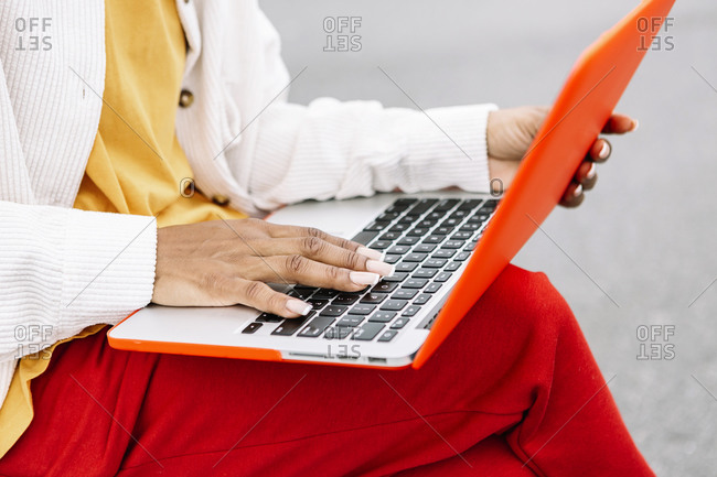 Woman working on laptop while sitting outdoors