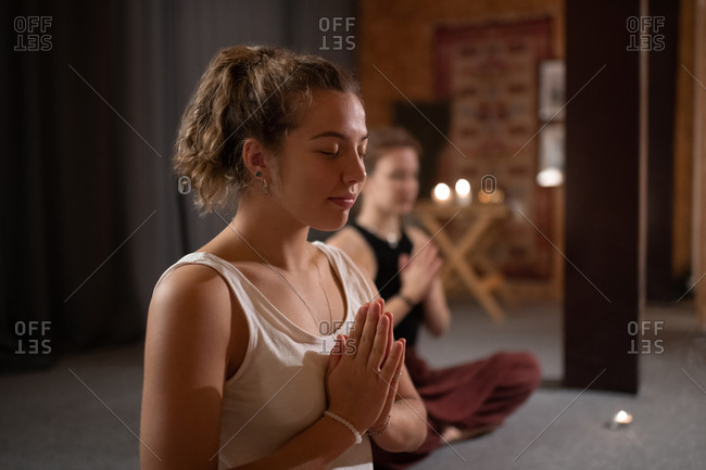 Glad female meditating during yoga session