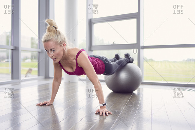 Determined fit woman training abs with Swiss ball
