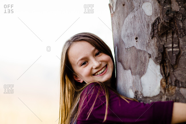 girl sitting against tree