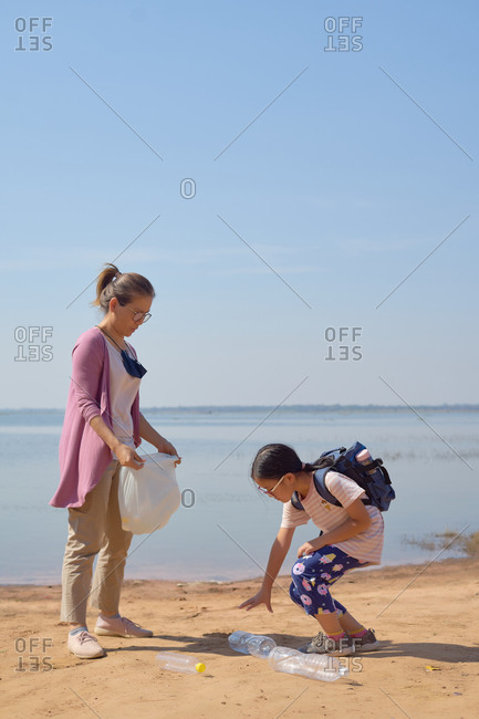 Daughter and mother collected plastic bottles by the lake together