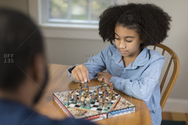 African America ten year-old girl playing board game with father
