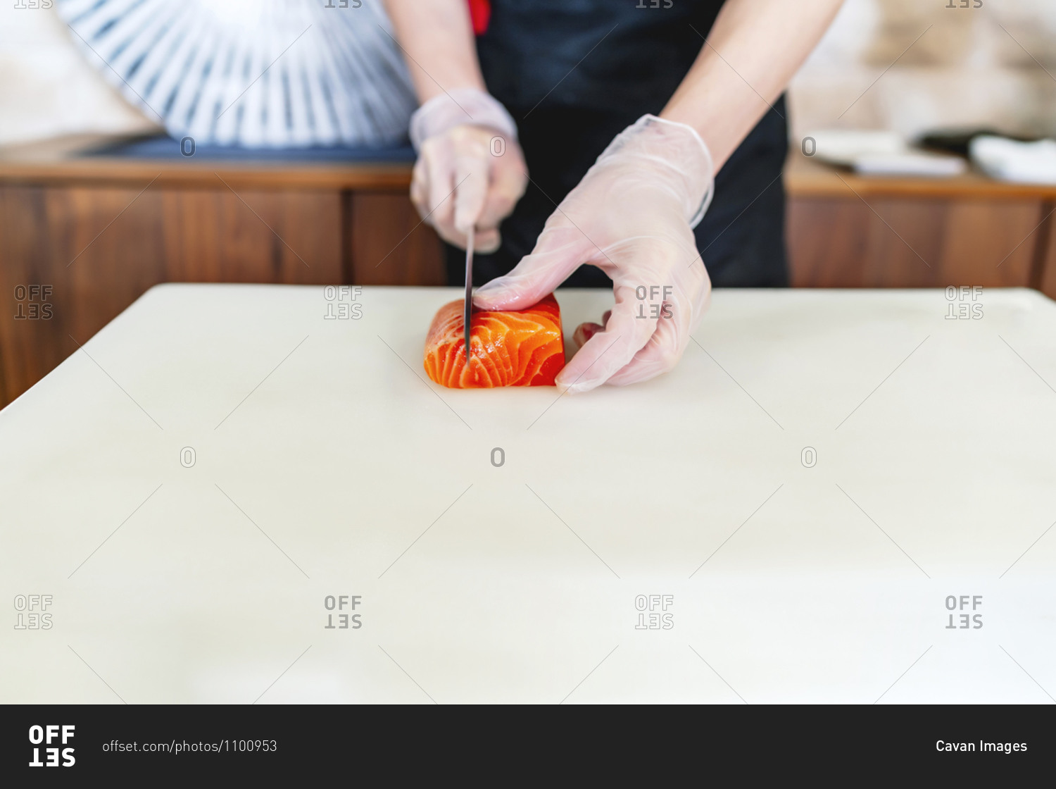 Japanese chef expert in sushi with his knife cutting salmon