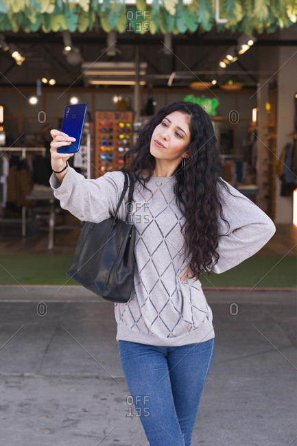 Pretty young woman makes a selfie on the city streets
