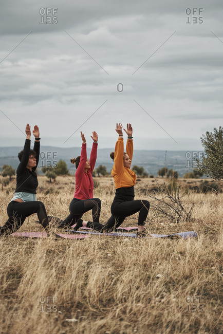 3 young women practicing pilates outdoors