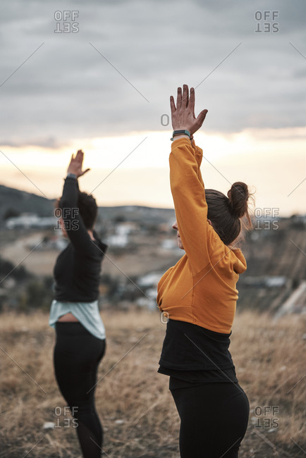 2 young women practicing pilates in the countryside