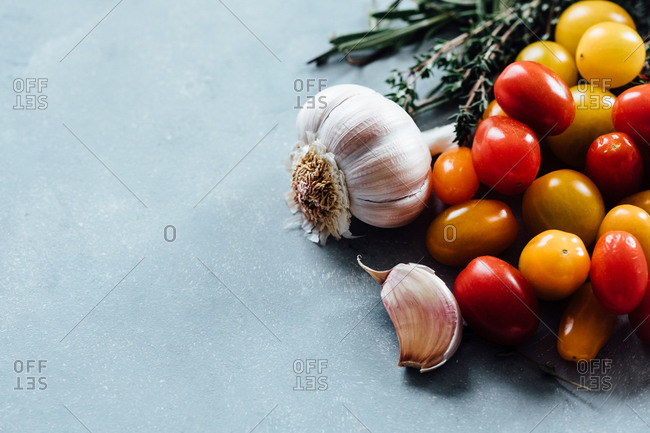 Tomatoes, garlic, and herbs on a wooden board