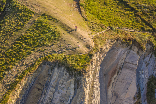 Aerial view of few tourists standing on the cliff near Sakoneta beach in Deba, Gipuzkoa state, Spain.