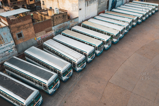 April 16, 2020: Gurugram, India16 April 2020: Aerial view of a line of public buses parked in a parking lot in Gurugram during lockdown, Haryana state, India.