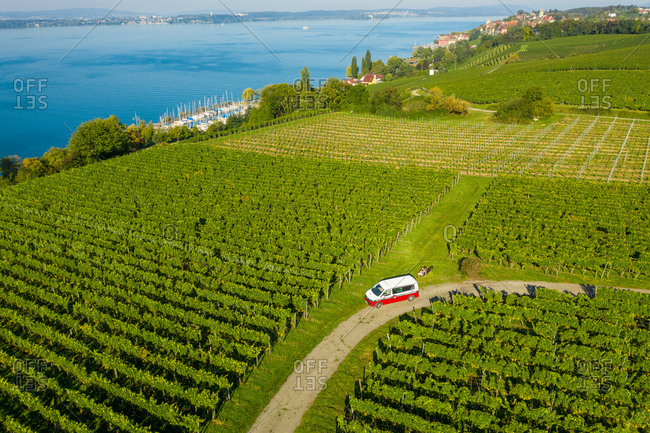September 8, 2020: Aerial view of a camper van driving a small road with vineyard along the Constance lake, Germany.