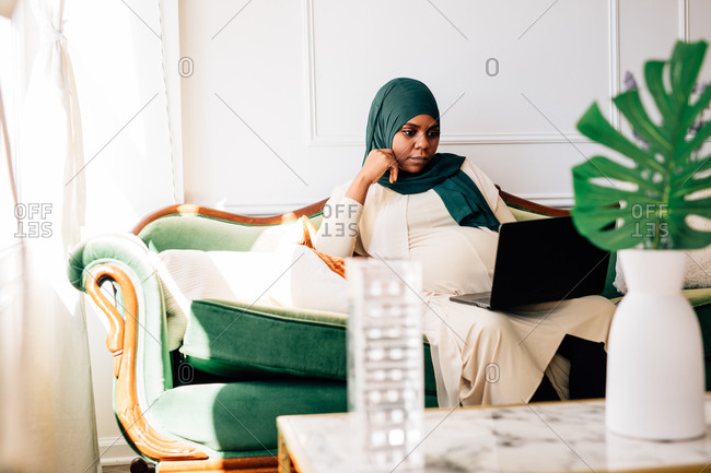 Professional Black woman working from home laptop, wearing a Hijab on video conference chat