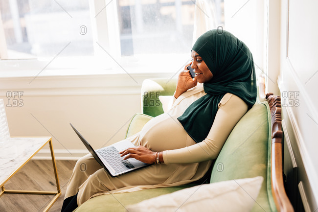 Professional Black woman working from home laptop, wearing a Hijab on video conference chat