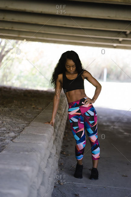 Vertical portrait of a black woman in athletic wear working outdoors