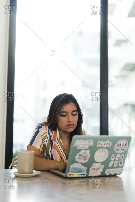 Asian woman working on a laptop at her desk