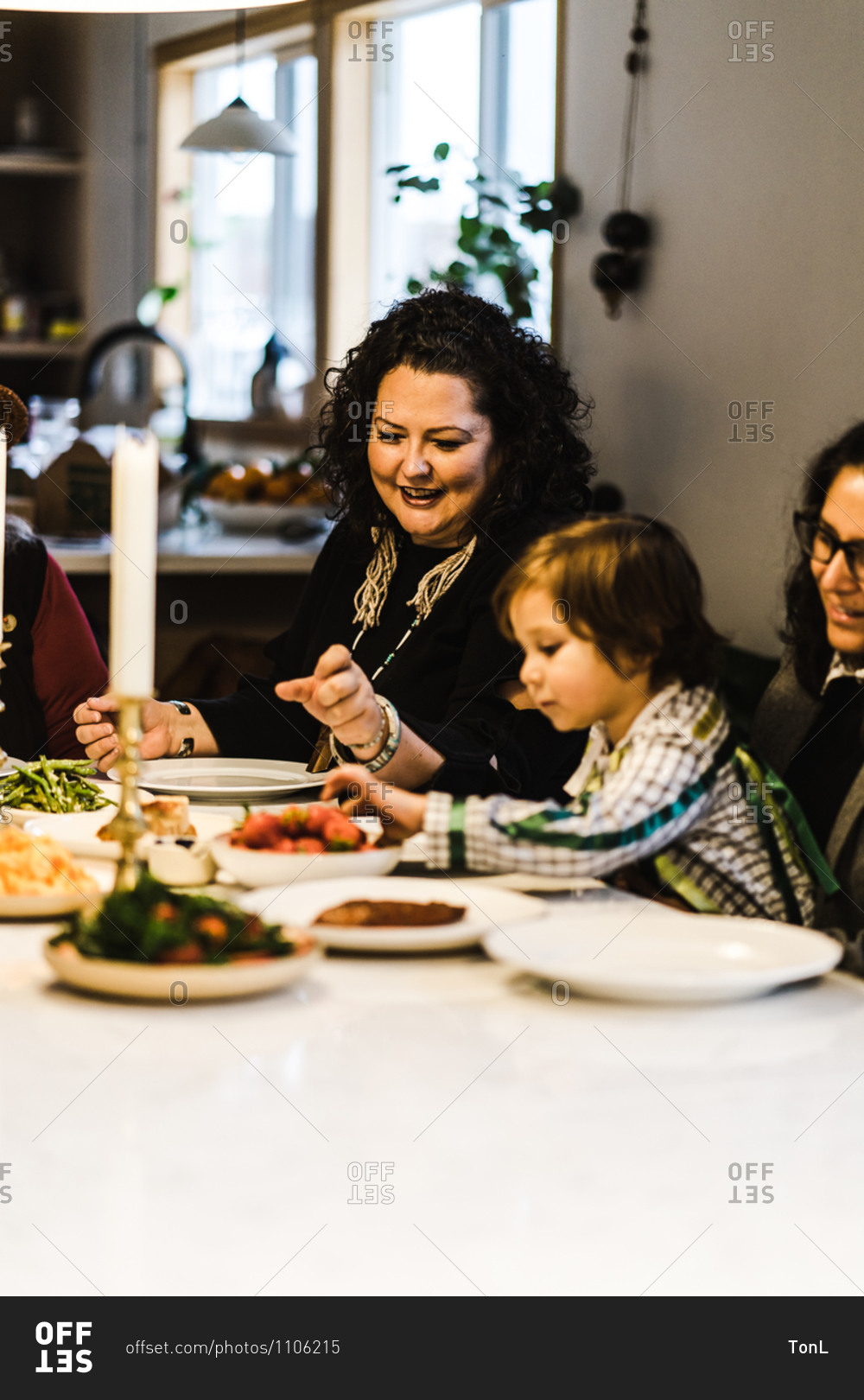 Horizontal shot of a joyous American Indian and Alaska native woman with her family at the dinner table for a meal