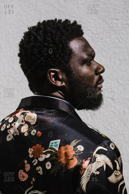 A side profile close up shot of a black man in a floral suit