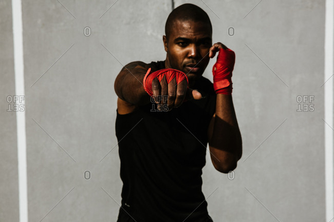 A strong black man punching during workout
