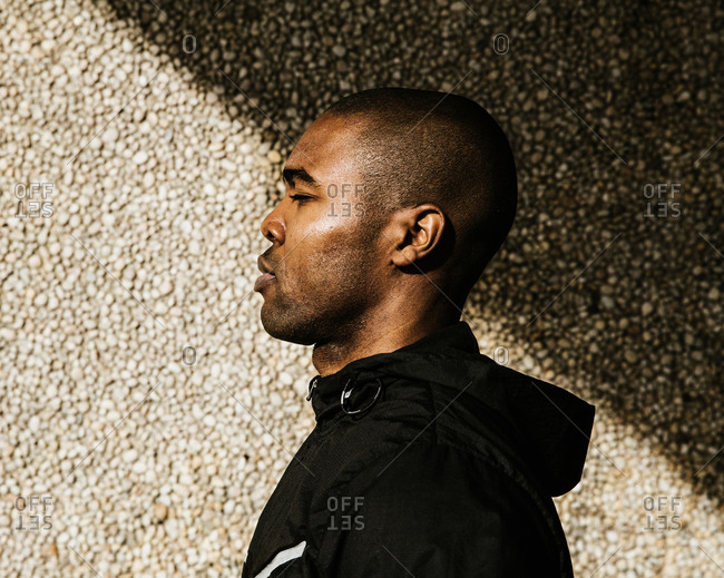 Side profile of a black male athlete wearing a hoodie