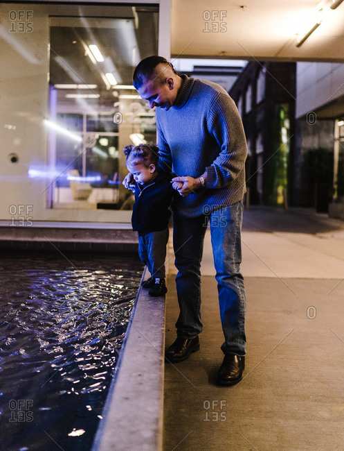 American Indian and Alaska Native father holding his daughter by fountain