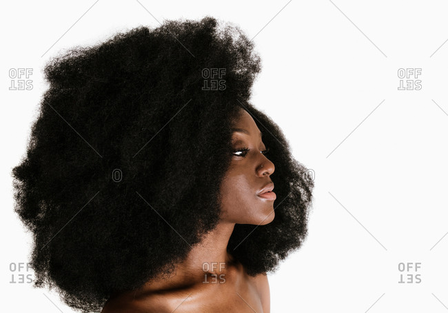 A side profile close up shot of a young black woman in a big afro hairstyle