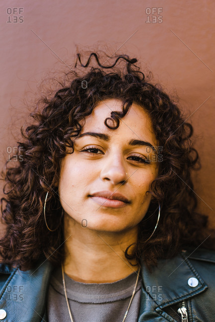 Portrait of a young Curly haired Latina woman wearing a black leather jacket