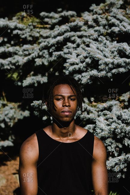 A portrait shot of a young African American muscular man wearing a black wifebeater