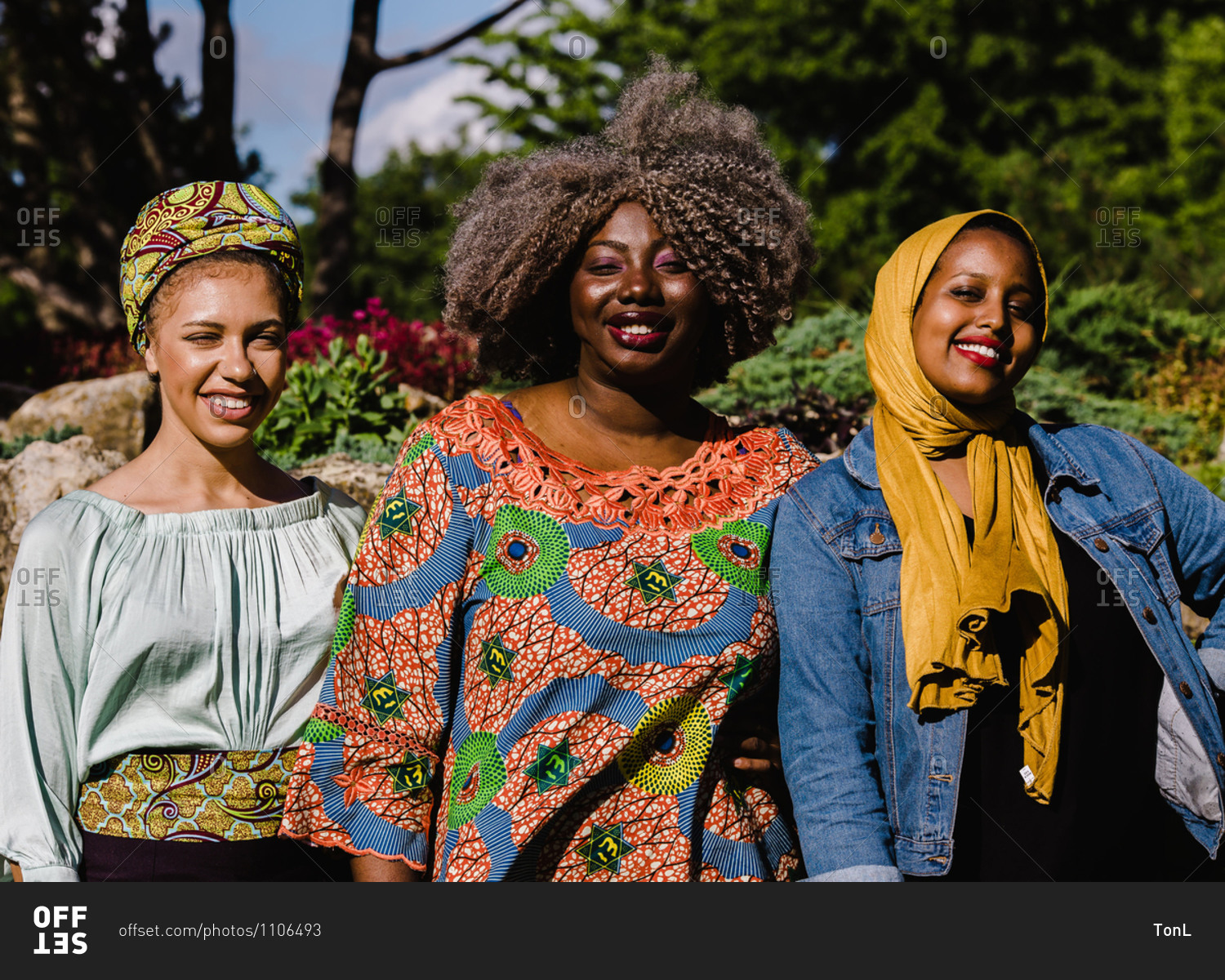 A group of three black Muslim women smiling and standing together stock ...